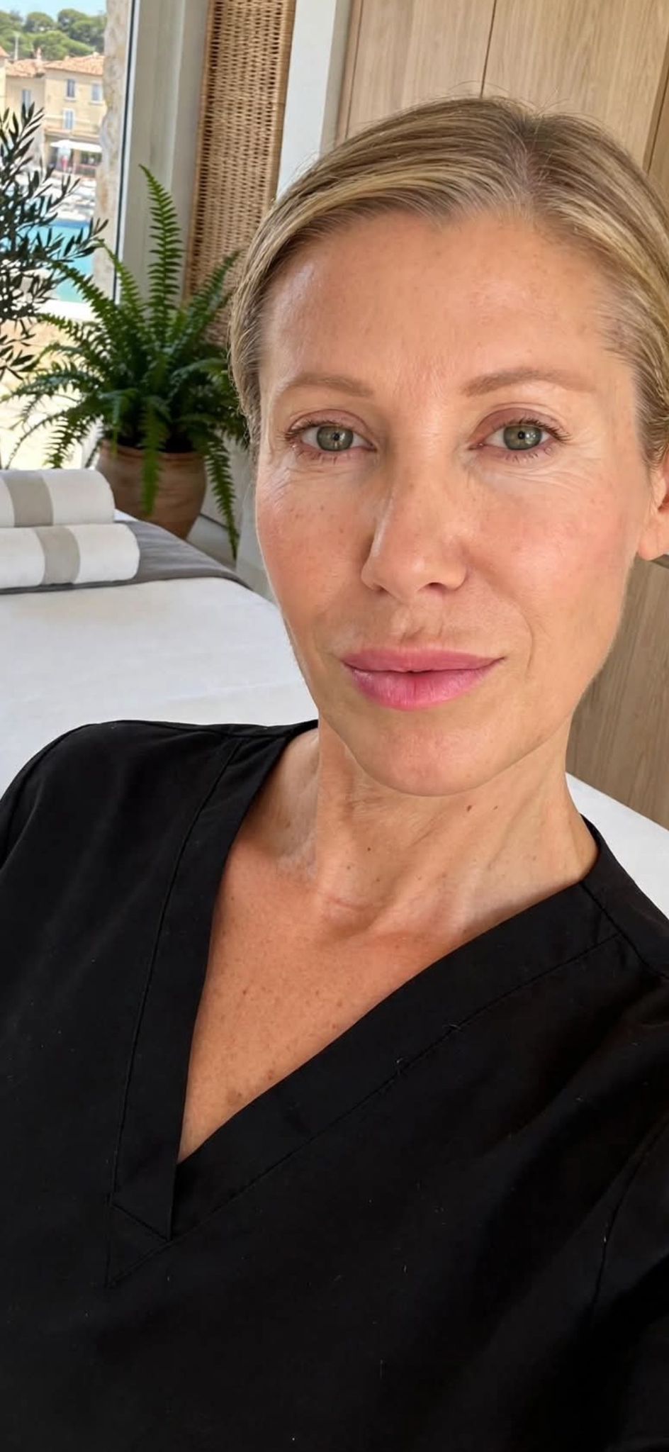 Portrait de Cristina Keller dans le studio d'Antibes, table de massage et vue sur le port en arrière-plan